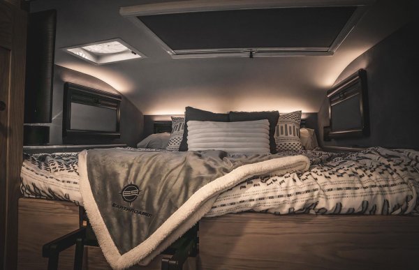 EarthRoamer SX съчетава здравина с много удобства вътре, което личи дори само по уютното легло California King. Със сигурност можем да си представим как гледаме нощното небе през стъклен капак на покрива. Елегантната маса за хранене може да побере удобно шестима през деня, а нощем става допълнителна спалня с друго легло California King. Или четири легла - в зависимост от вашите нужди.  Има и красиво завършена  баня с ръчен и обиковен душ.